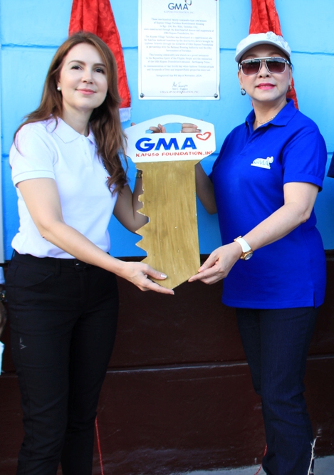 City Councilor Cristina Gonzales-Romualdez representing the City Government of Tacloban receives the ceremonial key to the Kapuso Village Tacloban from GMAKF EVP and COO Mel C. Tiangco.